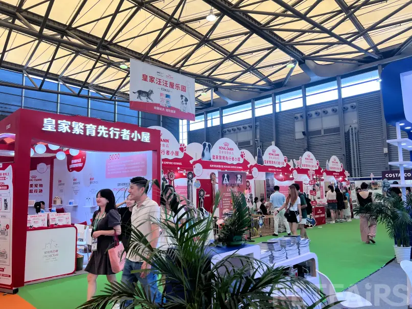 A panoramic view of Petfair Asia 2025 at the Shanghai New International Expo Centre, featuring crowded exhibition halls, international pet brands, and professional visitors.