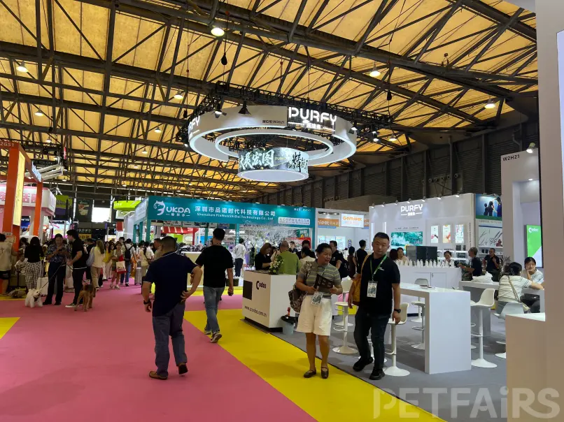 A panoramic view of Petfair Asia 2025 at the Shanghai New International Expo Centre, featuring crowded exhibition halls, international pet brands, and professional visitors.