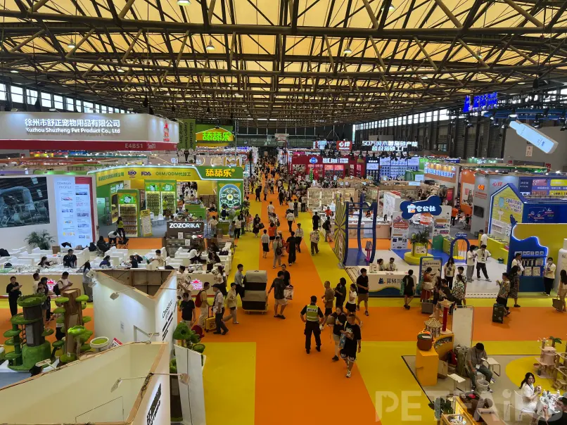 A panoramic view of Petfair Asia 2025 at the Shanghai New International Expo Centre, featuring crowded exhibition halls, international pet brands, and professional visitors.