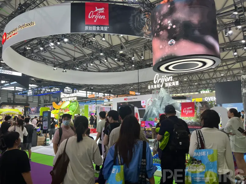 A panoramic view of Petfair Asia 2025 at the Shanghai New International Expo Centre, featuring crowded exhibition halls, international pet brands, and professional visitors.