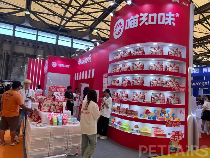 A panoramic view of Petfair Asia 2025 at the Shanghai New International Expo Centre, featuring crowded exhibition halls, international pet brands, and professional visitors.