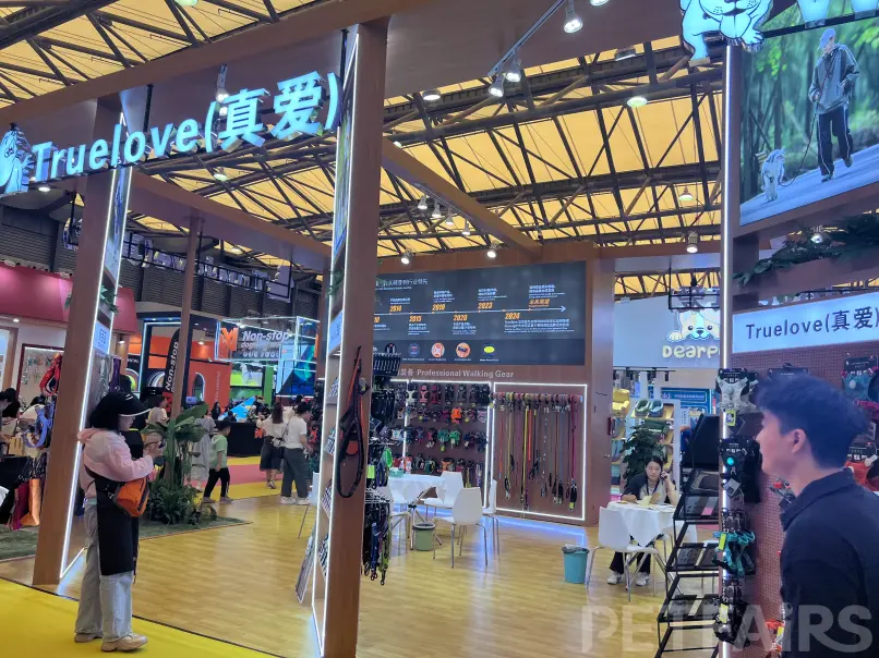 A panoramic view of Petfair Asia 2025 at the Shanghai New International Expo Centre, featuring crowded exhibition halls, international pet brands, and professional visitors.